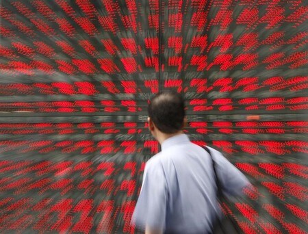 　７月１９日、日経平均をＴＯＰＩＸで割ったＮＴ倍率が１９年ぶりの高水準となっている。「値がさ株」が上昇する一方、時価総額の大きい銀行株などが伸び悩んでいるためだ。写真は都内の株価ボード前の通行人。２００７年７月撮影(２０１８年　ロイター／Toru Hanai)
