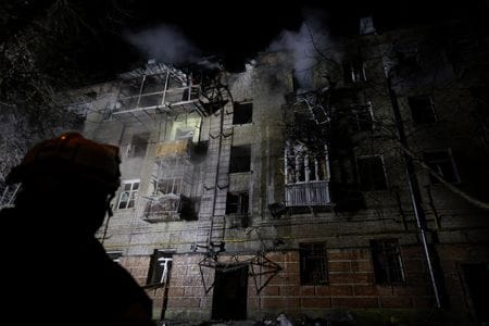 写真はロシアの攻撃で被害を受けた集合住宅と消防士。１月２４日、ハルキウで撮影。REUTERS/Sofiia Gatilova
