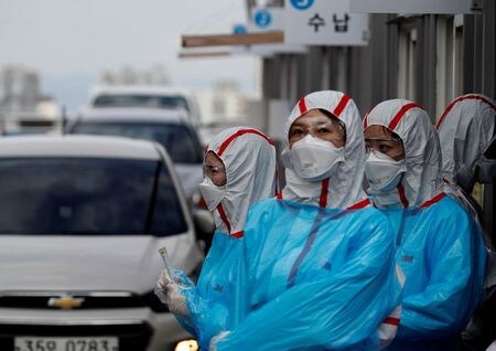 FILE PHOTO: Medical staff in protective gear work at a \'drive-thru\' testing center for the novel coronavirus disease of COVID-19 in Yeungnam University Medical Center in Daegu, South Korea, March 3, 2020. REUTERS/Kim Kyung-Hoon