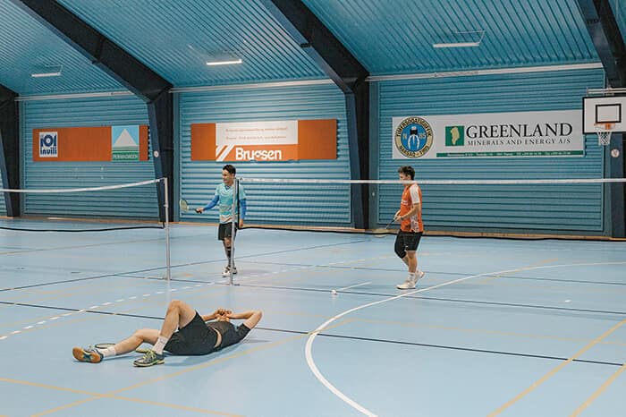 体育館の壁には「グリーンランド・ミネラルズ・アンド・エナジー（現エナジー・トランジション・ミネラルズ）」の看板。同社がナルサーク近郊で開発する鉱床にはウランが含まれるが、21年に政府がウラン採掘を禁止したため提訴している