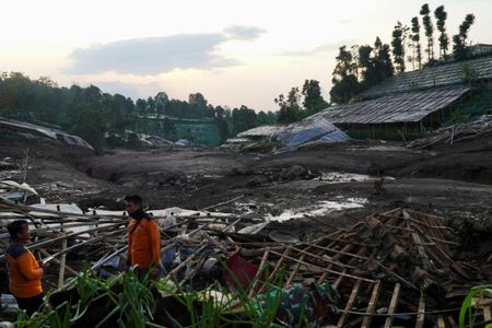 インドネシア西ジャワ州西バンドン市パシルラング村を襲った土砂崩れの後、被害を受けた家屋の近くに立つインドネシアの救助隊員たち。2026年1月24日撮影（2026年　ロイター/Yusep Maulana)