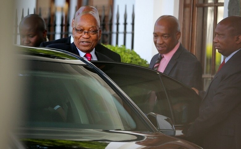 ２月６日、南アフリカの与党アフリカ民族会議（ＡＮＣ）は、ズマ大統領の去就について協議するとみられていた全国執行委員会（ＮＥＣ）の開催を延期した。一方、同国のニュースサイト、タイムズ・ライブは複数の関係筋の話として、一定の条件が整えば辞任する用意があるとズマ大統領が述べたと報じた。委員会延期の発表後、政府庁舎を後にする同大統領（左）。ケープタウンで撮影（２０１８年　ロイター／Sumaya Hisham）