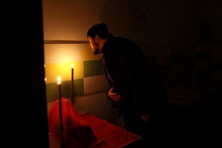 　ウクライナのゼレンスキー大統領は４日夜の演説で、越冬に向け国民に忍耐と団結を呼びかけた。国内では電力などの復旧作業が続けられている。写真は停電している教会で礼拝後にろうそくを消す神父。シベルスクで撮影（２０２２年　ロイター／Leah Millis）