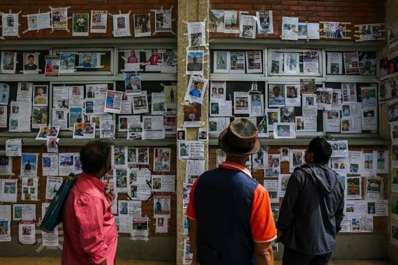 9月2日、カトマンズにある病院の外壁に貼られた行方不明者の写真を見る人々。 REUTERS/Athit Perawongmetha