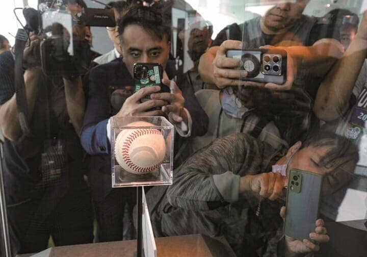 台北で展示された大谷翔平の「50 - 50」の記念球の写真を撮る人たち