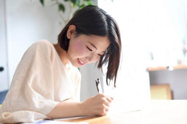 笑顔で資格取得の勉強をする女性のイメージ