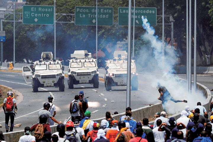 カラカスの空軍基地の近くで機動隊と対峙する反政府デモ　CARLOS GARCIA RAWLINSーREUTERS