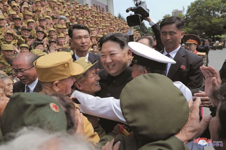 朝鮮戦争の休戦協定締結から69年を祝って、平壌で元兵士らと記念撮影に臨む金正恩（2022年7月28日）　KCNAｰREUTERS