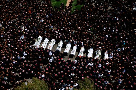 ７月２８日、    イスラエルが占領するゴラン高原への２７日のロケット弾攻撃を受け、同国の安全保障内閣は２８日、対応の「方法と時期」を決定する権限を政府に認めた。写真は攻撃を受け死亡した子供らの葬儀。マジダルシャムスで２８日撮影（２０２４年　ロイター/Ammar Awad）