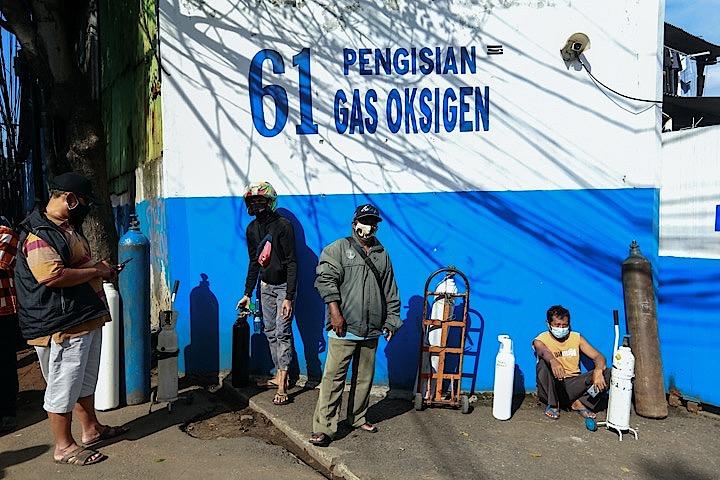 インドネシア・ジャカルタで、酸素吸入用のボンベに酸素を充填してもらう人びと　REUTERS/Ajeng Dinar Ulfiana