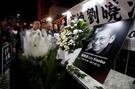 　７月１３日、中国の民主活動家でノーベル平和賞を受賞した作家の劉暁波氏が、多臓器不全のため死去した。劉氏を追悼する民主活動家、香港にある中国の連絡弁公室前で撮影。（２０１７年　ロイター／Bobby Yip）