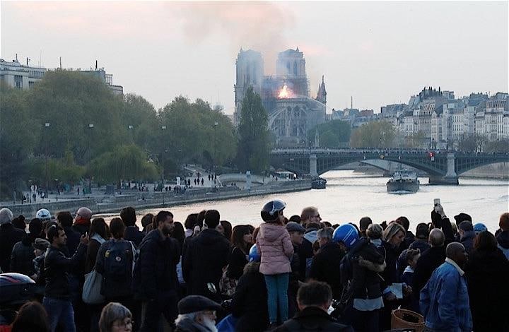 15日、仏パリのノートルダム寺院で大規模な火災が発生。世界的に愛されている歴史的建造物の大聖堂から巨大な炎が上がり、取り乱したパリっ子や、ショックを受けた観光客らは信じられない面持ちでその状況を見守った。ノートルダム寺院の火災を見つめる市民ら（2019年　ロイター/Charles Platiau）