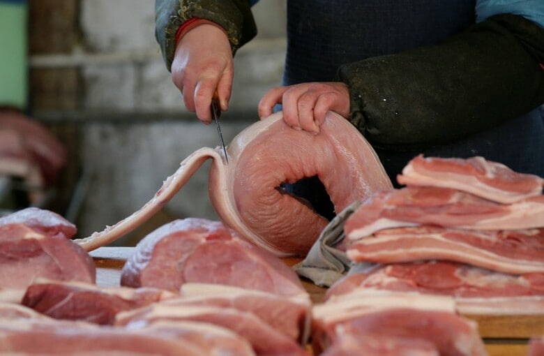２０１６年３月、北京の市場で豚肉を切る精肉店員（２０１８年　ロイター/Jason Lee）