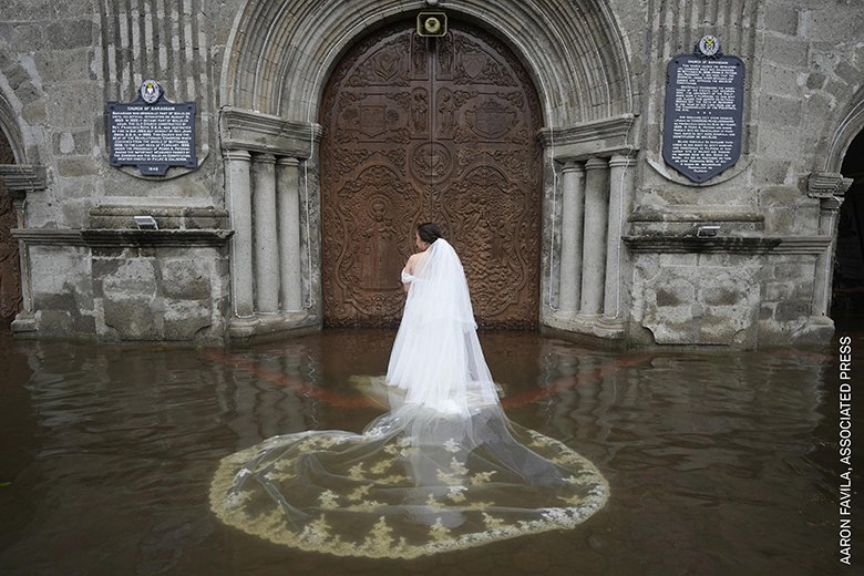 「ストーリー（アジア太平洋・オセアニア）」部門 『洪水の中の結婚式』 »Aaron Favila　台風で浸水したフィリピンのバラソアイン教会で結婚式に臨む花嫁（昨年7月22日）。厳しい状況に直面しても揺るがぬ愛と不屈の精神を表す。教会のあるブラカン州は老朽化した排水システム、気候変動などにより、頻繁かつ深刻な洪水の脅威にさらされている