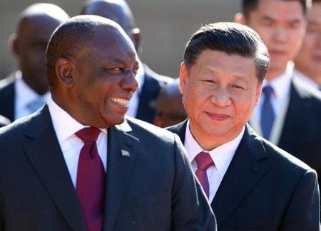 　７月２４日、中国の習近平国家主席は、南アフリカに対して１４７億ドルの投資を約束した。会談前に並んで歩く南アのラマポーザ大統領(左）と同主席(右）。プレトリアで撮影(２０１８年　ロイター／Mike Hutchings)