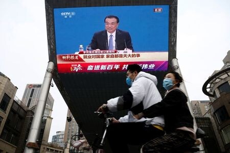 １１月１９日、中国の李克強首相は財界人との会合で、国内経済は新たな下方圧力に直面しており、内外の情勢は依然として複雑で厳しいとの認識を示した。写真は北京市内のモニターに映った李首相。３月撮影（２０２１年　ロイター/Tingshu Wang）