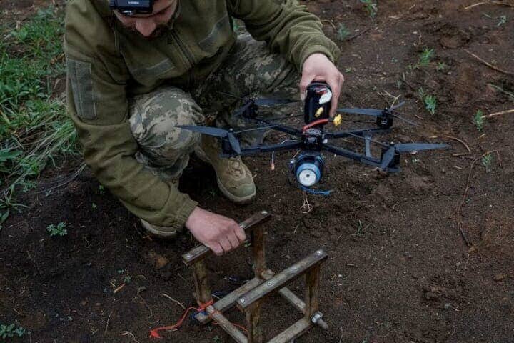 ウクライナ軍とロシア軍が対峙（たいじ）する最前線地帯は幅約１０キロメートルにわたってドローンがひしめき合っており、ウクライナ兵は「殺戮（さつりく）ゾーン」と呼ぶ。写真はＦＰＶ（ファースト・パーソン・ビュー、一人称視点）のドローンを準備するウクライナ兵。５月８日、同国中部ドニエプロペトロフスク州の前線付近で撮影（２０２５年　ロイター/Alina Smutko）