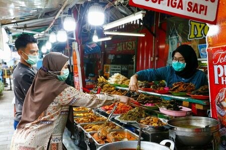 　４月１４日、ロイターの集計によると、新型コロナウイルスの感染者は世界全体で１億３７０３万人を超え、死者は３０９万０７２８人となった。写真はジャカルタで１３日撮影（２０２１年　ロイター／Ajeng Dinar Ulfiana）