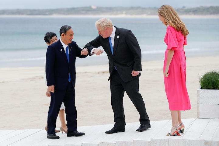 G7首脳会議が開かれるコーンウォールの海岸でコロナ式挨拶を交わすジョンソン首相夫妻と菅首相夫妻（6月11日）　Phil Noble-REUTERS