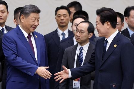 アジア太平洋経済協力会議（APEC）首脳会議で韓国の李在明大統領（右）と握手する中国の習近平国家主席。2025年11月1日、韓国・慶州で撮影。   （２０２５年　ロイター/Yonhap）