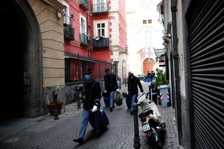 １０月１８日、イタリアのコンテ首相は新型コロナウイルス感染拡大防止のための追加的な制限措置を発表するとともに、各市町村長に人々の集会を阻止するために公共広場を午後９時以降閉鎖する権限を与えた。写真は１６日、ナポリの軍学校がコロナ対策の一環で閉鎖され、帰宅の途に就く学生（２０２０年　ロイター/Ciro De Luca）