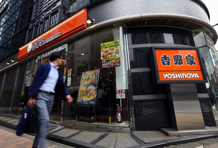 吉野家の店舗前を歩く男性。2025年5月、都内で撮影。  REUTERS/Issei Kato