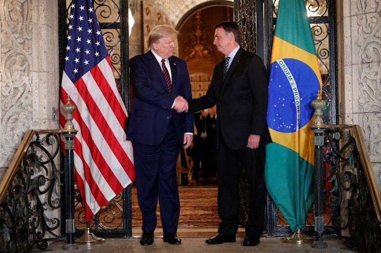 ブラジルのボルソナロ大統領（右）の新型コロナウイルス感染が確認されたと、FOXビジネス・ネットワークが報じた。写真は3月7日、フロリダ州パームビーチで行われたトランプ米大統領（左）との会談で撮影。（2020年　ロイター/Tom Brenner）