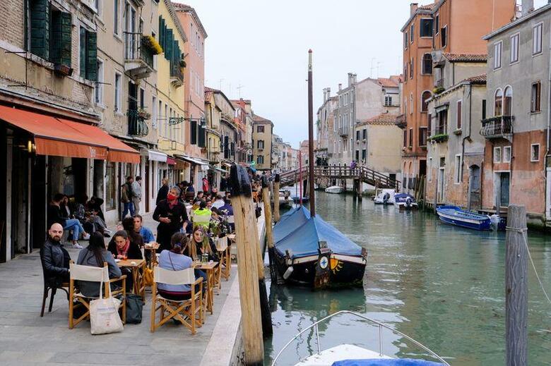 欧州で新型コロナウイルス感染状況が落ち着く中、イタリアで２６日、大部分の地域で飲食店や映画館などの営業が再開したほか、フランスのマクロン大統領は今後の状況を見ながら地域ごとに段階的に再開していく方針を示した。ベネチアの飲食店のようす（２０２１年　ロイター／Manuel Silvestri）