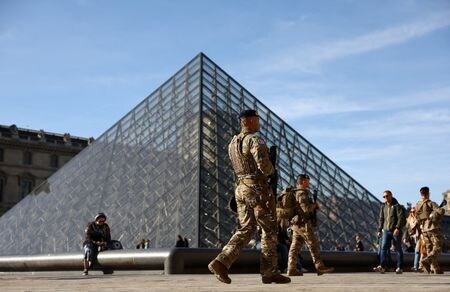 仏ルーヴル美術館のガラスのピラミッド前をパトロールする警官。2025年10月30日撮影。REUTERS/Abdul Saboor