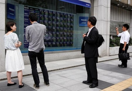 　９月１３日、前場の東京株式市場で、日経平均株価は前日比９３円２０銭高の１万９８６９円８２銭となり３日続伸した。写真は都内にある証券会社の株価ボード前で昨年６月撮影（２０１７年　ロイター／Thomas Peter）