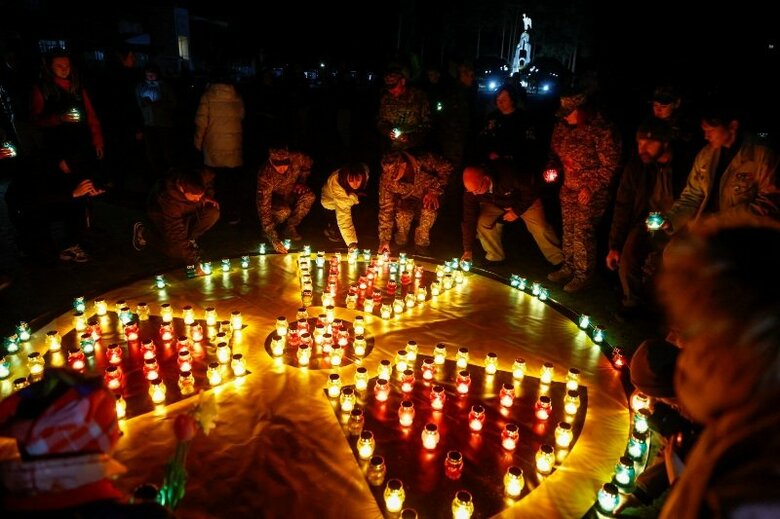 4月25日、ウクライナのスラビティチでろうそくを灯す人々。REUTERS/Valentyn Ogirenko