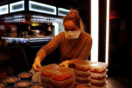 ロシアのムラシュコ保健相は３日、国内で新型コロナ感染拡大が続く中、国民の日常生活は少なくとも来年２月までは通常状態に戻らないとの見解を示した。写真は４月１４日、コロナ感染で外出できない高齢者向けの食事を用意するモスクワのレストランオーナー（２０２０年　ロイター/Maxim Shemetov）