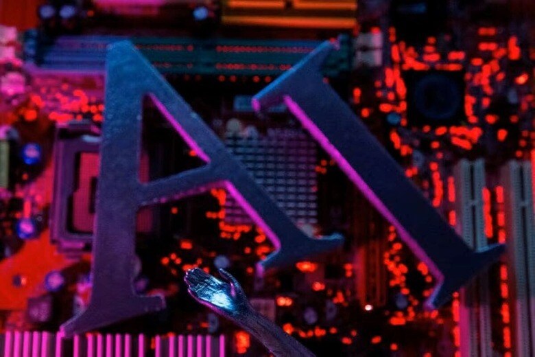 １０月１日、米アルファベット傘下のグーグルはマレーシアへの投資で２万６５００人の雇用が創出されると表明、２０３０年までに同国で３０億ドル以上の経済効果を期待できるとの見通しを示した。写真は、コンピュータのマザーボード上のAIの文字とロボットの手。２０２３年６月撮影（２０２４年　ロイター/Dado Ruvic）
