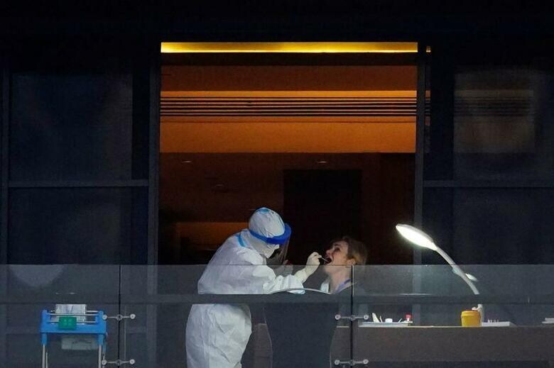 新型コロナウイルスの起源を探るため中国湖北省武漢市を訪問しているWHO調査団のメンバーは、コウモリが生息する洞窟でウイルスの遺伝要素を追跡する作業が必要との見方を示した。武漢のホテルでPCR検査を受ける調査団メンバー、3日撮影（2021年　ロイター／Aly Song）