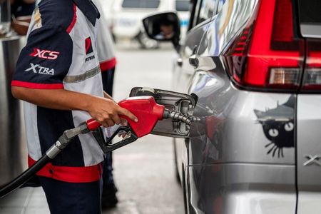 写真はガソリンスタンドで給油する従業員。3月9日、フィリピンのマニラ首都圏ケソン市で撮影。REUTERS/Lisa Marie David