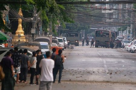 　３月１０日、ミャンマー国軍が、国際社会に同国の「実情の説明するのを支援する」目的でカナダのロビイストを報酬２００万ドルで雇ったことが米司法省に提出された文書で明らかになった。写真は警察車両をみる人々。ミャンマーのヤンゴンで８日撮影（２０２１年　ロイター／Stringer）