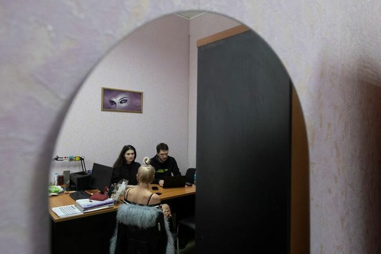 １月２９日、ウクライナのイジュムで、２０２２年にロシア軍の拷問を受けたと語る女性の話を聞くＮＧＯ「トゥルース・ハウンズ」のメンバーら。REUTERS/Thomas Peter