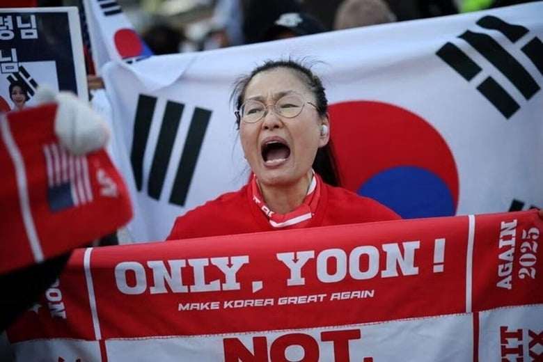 韓国・ソウルの裁判所前で、尹錫悦前大統領を支持するサインを掲げる女性。13日撮影。REUTERS/Kim Hong-Ji
