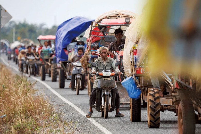 タイと国境を接するカンボジア北部のウドーミエンチェイ州で、避難民キャンプに入る順番を待つ車列。両国の避難民は約60万人に達している（12月10日）　KIM HONG-JIｰREUTERS