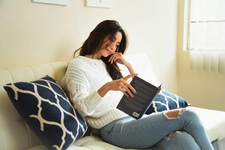 ソファで読書する女性