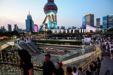 2025年7月14日、中国上海の陸家嘴金融街にある歩道橋を歩く人々。ロイター/中村豪/ファイル写真