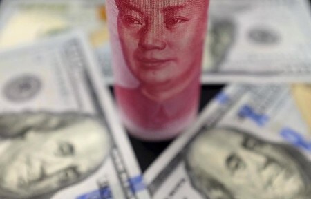 　１月５日、中国政府が今週発表する１２月末の外貨準備は、２０１１年２月以来の低水準になると予想される。そこで投資家の間では、果たして中国当局が人民元の防衛を続けられるのかという点だけでなく、さらなる資金流出と通貨安の悪循環が始まる恐れも大きな不安の種になっている。写真は人民元とドル紙幣。北京で昨年１月撮影（２０１７年　ロイター/Jason Lee）