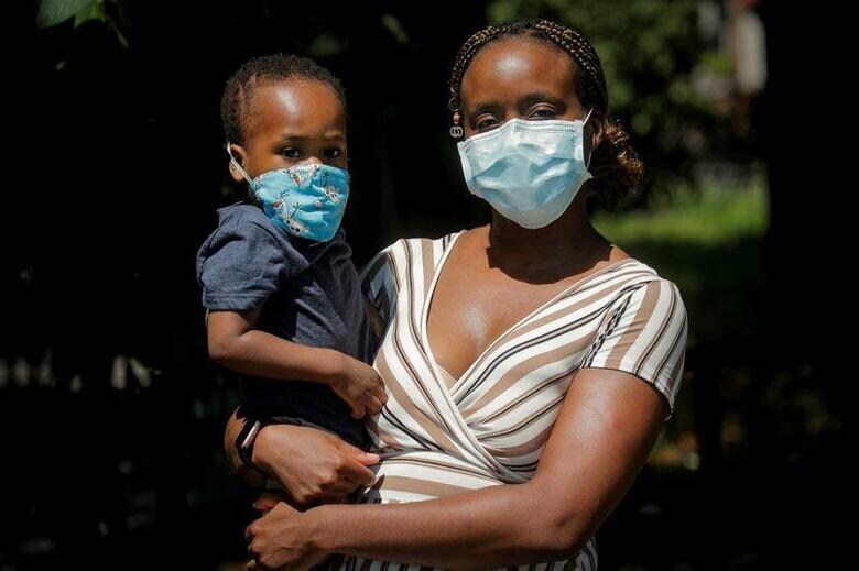 新型コロナウイルスによるパンデミック(世界的な大流行)が保育サービスに大きな打撃を与えたことで、特に母親を中心に、米国の親たちの多くは厳しい選択に直面している。写真は7月、ニューヨークのブルックリン地区で息子と写真撮影に応じるシャンテル・スプリンガーさん(2020年　ロイター/Brendan McDermid)