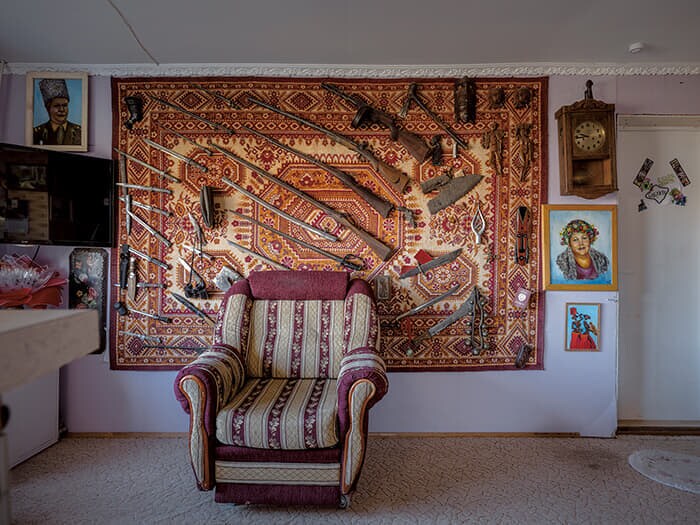モーテルの一室に飾られたタペストリーと武器。オーナーの夫(左上の肖像画)はソ連の将校だった