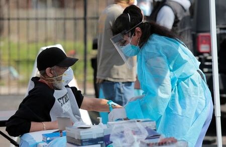 　５月２１日、ロイターが人口データと公衆衛生データを分析したところ、米国では民主党支持者の多い地区で、新型コロナウイルス感染症の死亡率が高いことが明らかになった。同地区の死亡率は共和党支持者の多い地区の３倍に達している。写真はデトロイトで新型コロナの検査を受ける市民。４月撮影（２０２０年　ロイター/Rebecca Cook/File Photo）