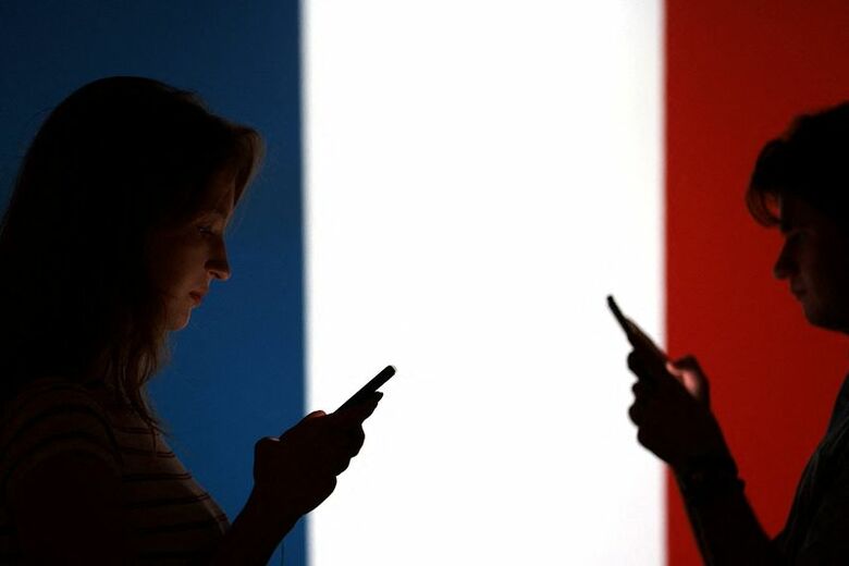 写真はフランス国旗とスマートフォンのイメージ。2025年9月撮影。 REUTERS/Dado Ruvic/Illustration