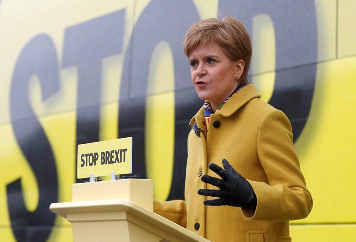 「EU離脱を止めよう」と書いたサインの前で演説するスコットランド自治政府のスタージョン首相（12月5日）　Russell Cheyne-REUTERS