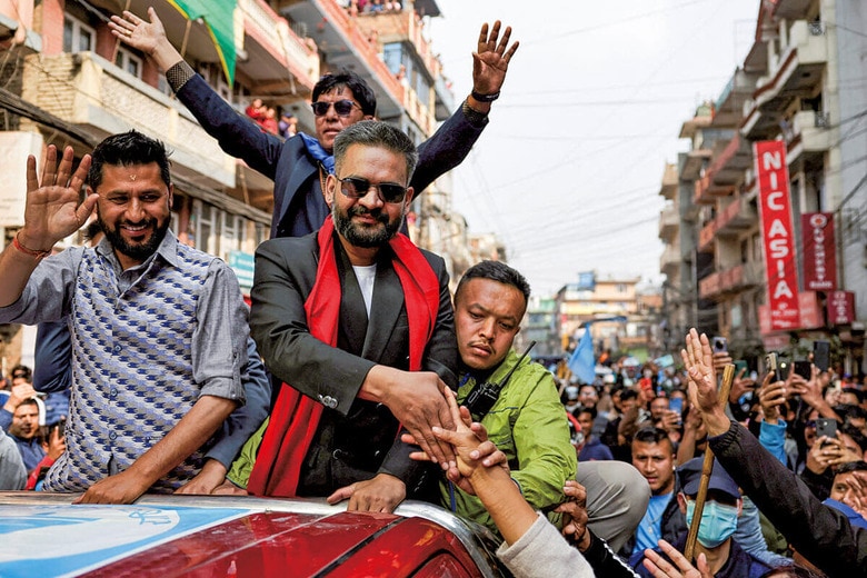 圧倒的な人気を誇るシャー（車上中央）はRSPのラミチャネ党首（左）と共に選挙運動に臨んだ　NAVESH CHITRAKARｰREUTERS