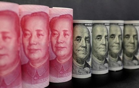 　１２月２８日、中国は、外国企業が中国経済への再投資で得た利益について、法人所得税の支払いを一時的に免除すると発表した。写真は人民元とドルの紙幣、昨年１月撮影（２０１７年　ロイター/Jason Lee）