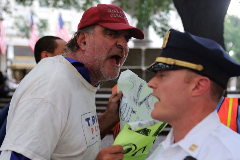 反トランプ派のデモ現場で警察官に向かって叫ぶトランプ支持者の男性（8月31日）　Joe Penney-REUTERS